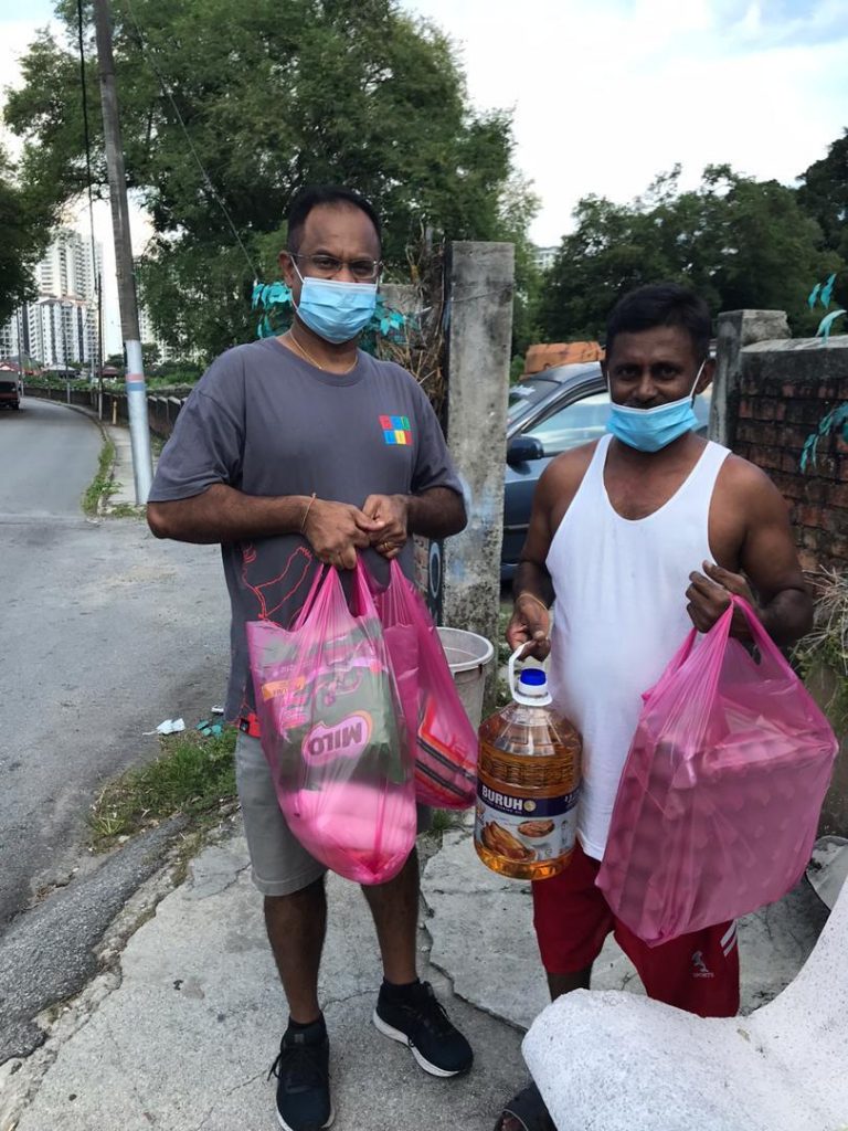 James (left) giving out food parcels at Hong Seng area.