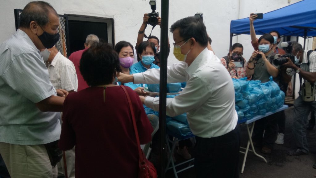 Chow (right) handing out food parcels to the underprivileged.